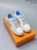 Pair of white and light blue low-top sneakers displayed on an orange shoebox.