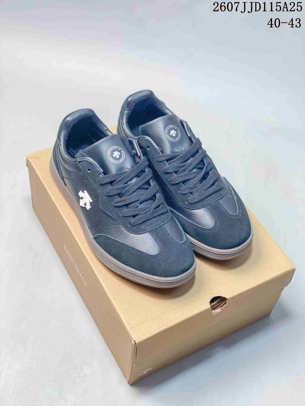 Pair of dark Descente low-top sneakers displayed on a shoe box, with the size range 40–43 shown in the image.