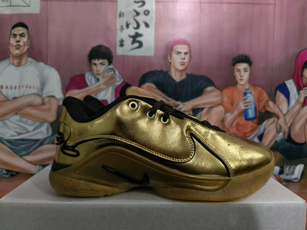 Side profile of a gold-tone Nike basketball sneaker with black accents and a gum-colored outsole.