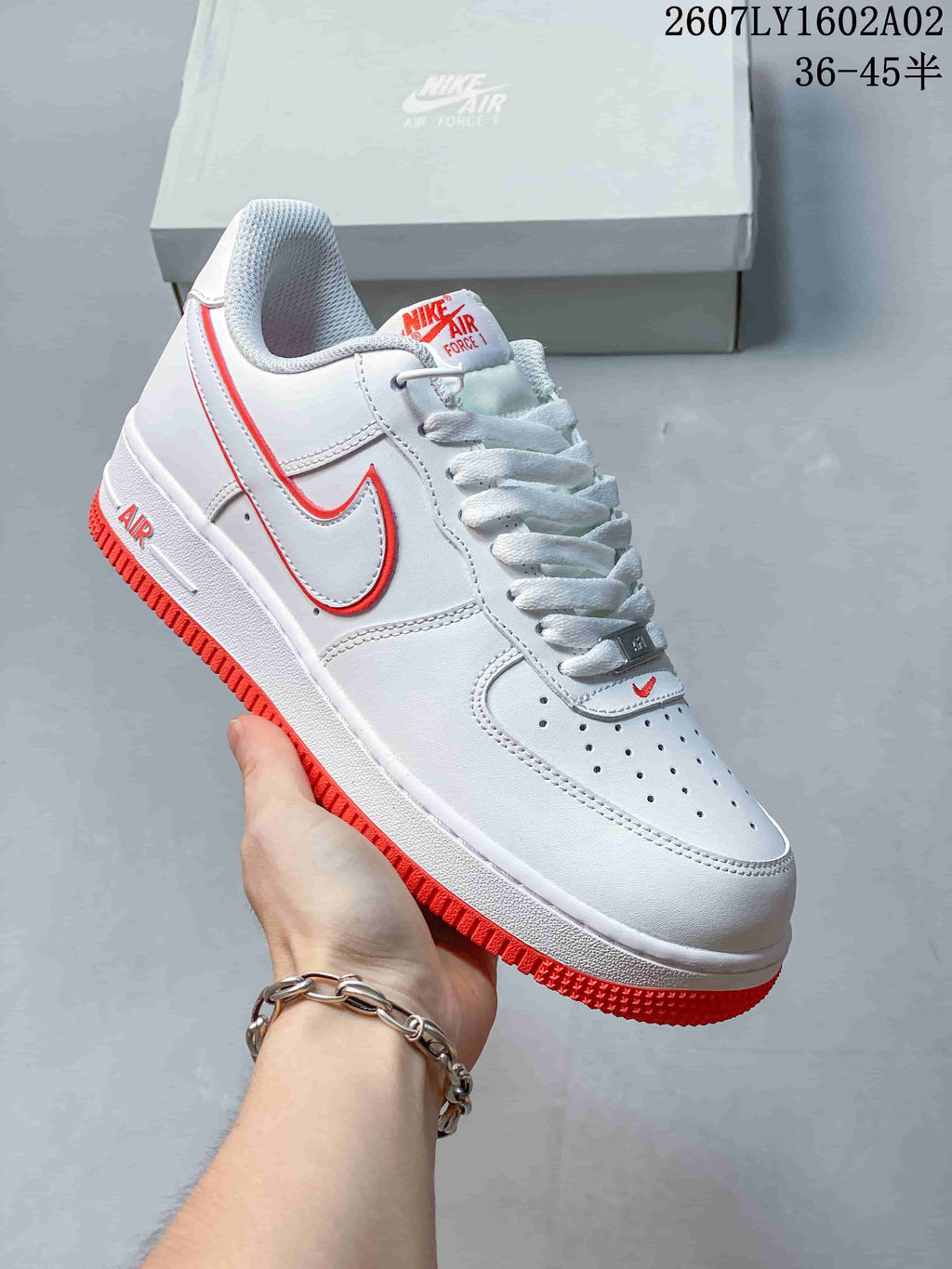 Angled view of a white Nike Air Force 1 ’07 low-top sneaker with red accents.