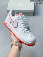 Angled view of a white Nike Air Force 1 ’07 low-top sneaker with red accents.