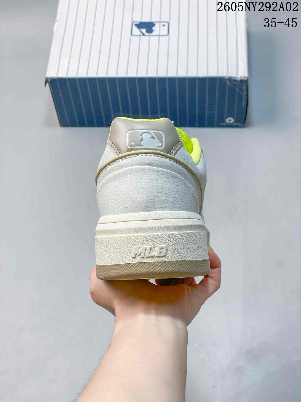 Rear view of the white sneaker showing the MLB heel mark, layered sole, and neon-green lining.