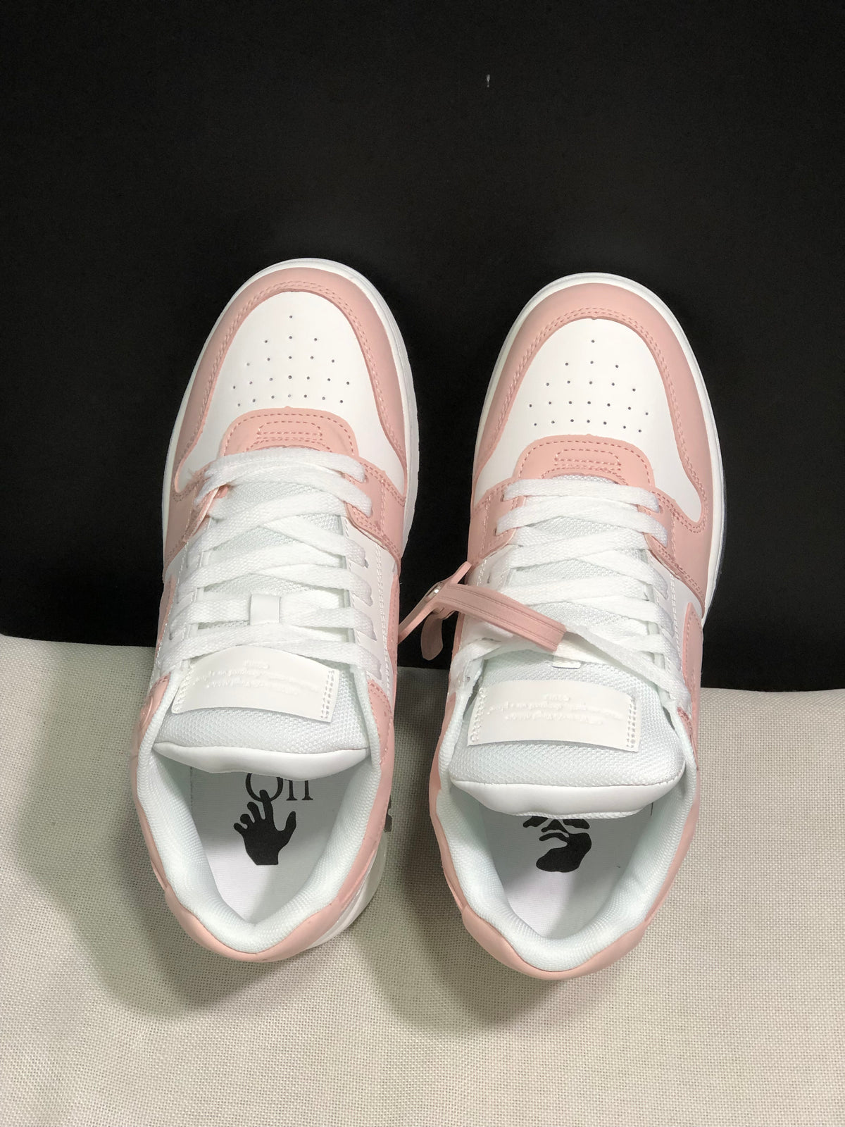 Top view showing white laces, perforated toe boxes, pale pink overlays, and printed insoles.