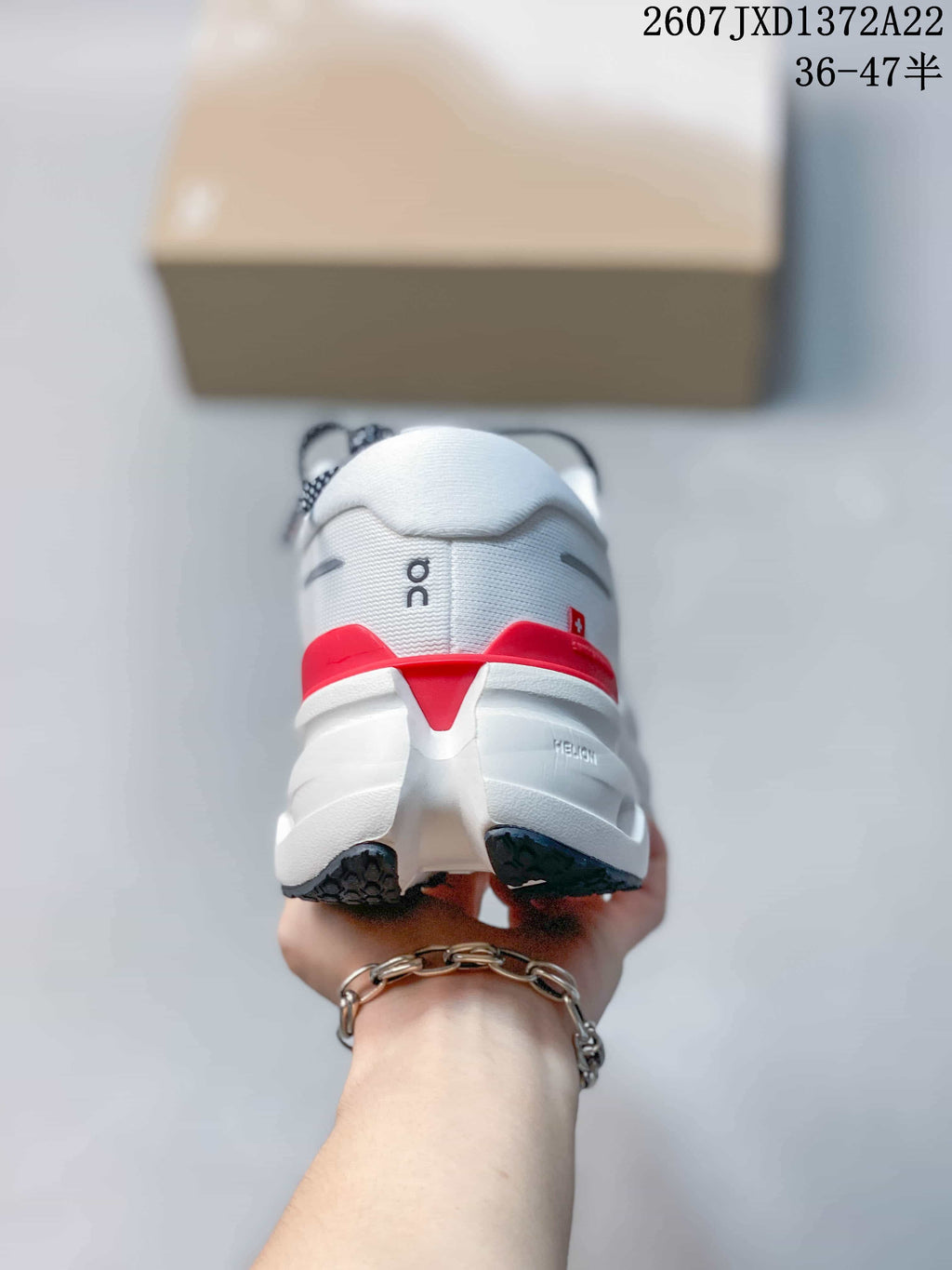 Rear view of a white sneaker showing the padded heel, red heel accent, and segmented sole.