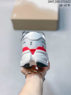 Rear view of a white sneaker showing the padded heel, red heel accent, and segmented sole.