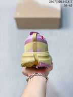 Rear view of the pink and yellow sneaker showing the padded collar, heel pull tab, and contrasting outsole sections.