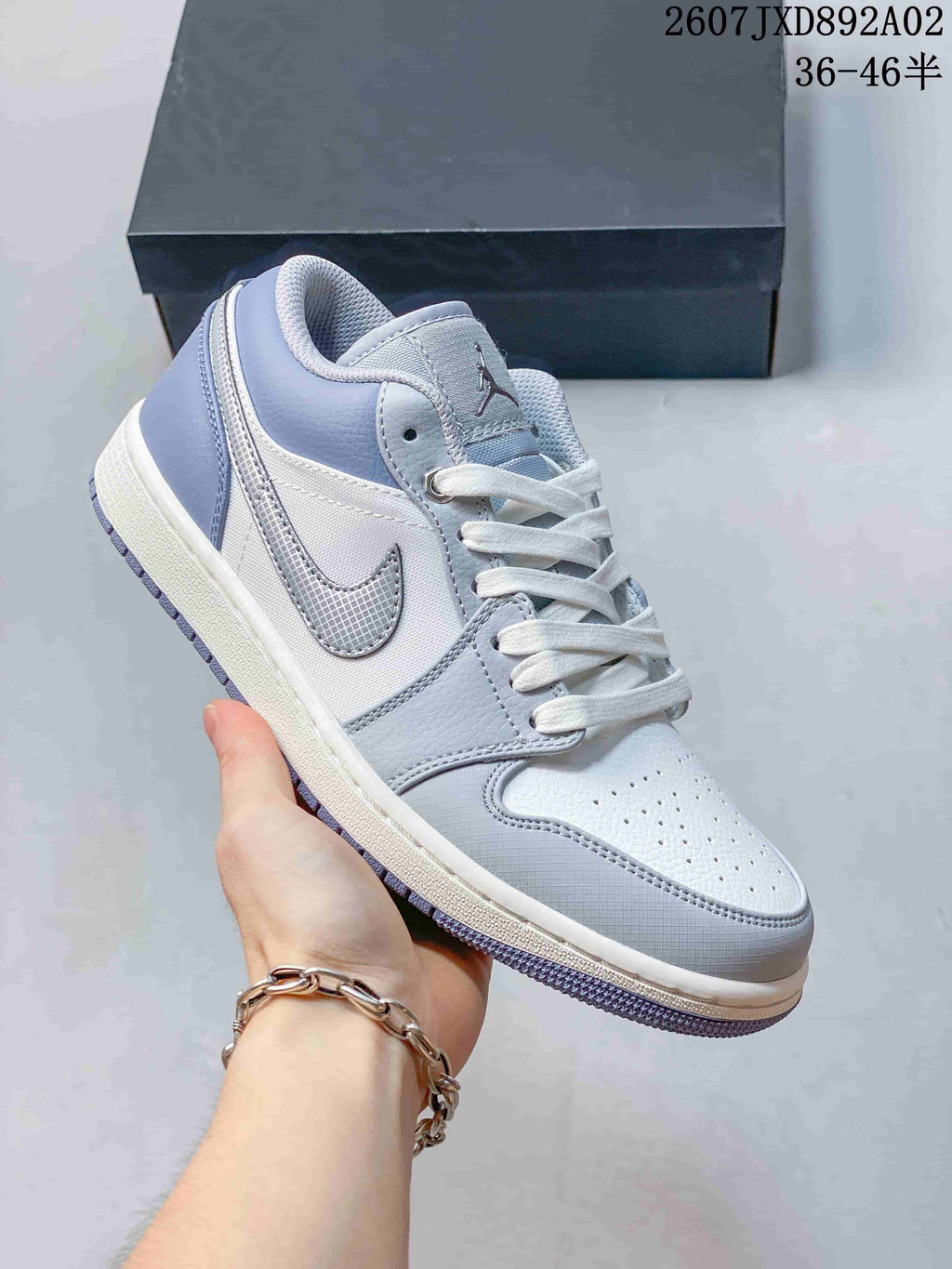 Angled view of the sneaker showing its white and blue-gray panels and side Swoosh.