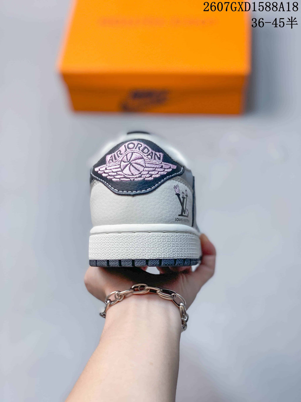 Rear view of a low-top sneaker showing a winged basketball emblem on the heel, white heel panel, and dark outsole trim.