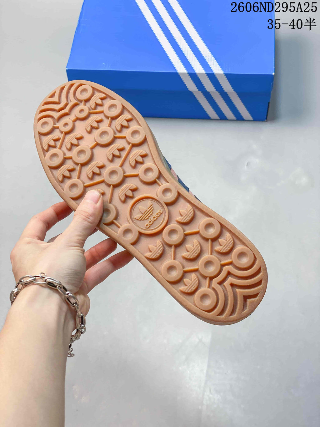 Close view of the gum-colored outsole showing its circular and trefoil-inspired tread pattern.
