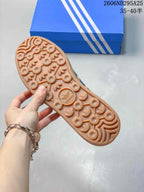 Close view of the gum-colored outsole showing its circular and trefoil-inspired tread pattern.