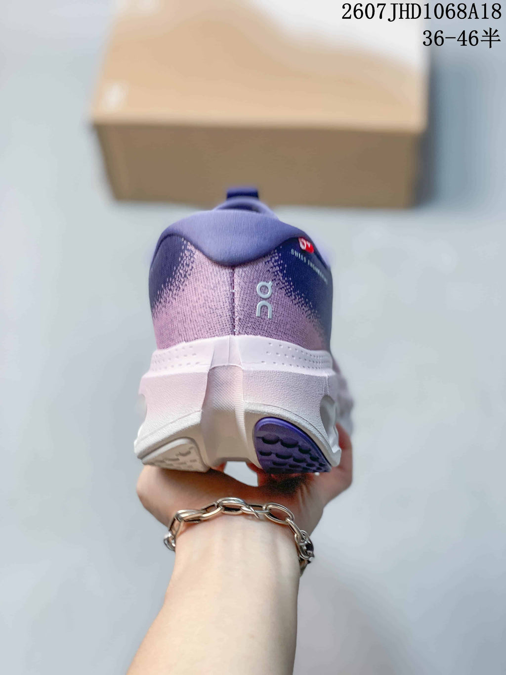 Rear view of one purple sneaker showing the padded heel collar, white midsole, and purple outsole section.