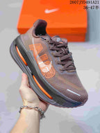 Angled side view of the brown sneaker showing the orange side graphic, lace system, and visible midsole cushioning.
