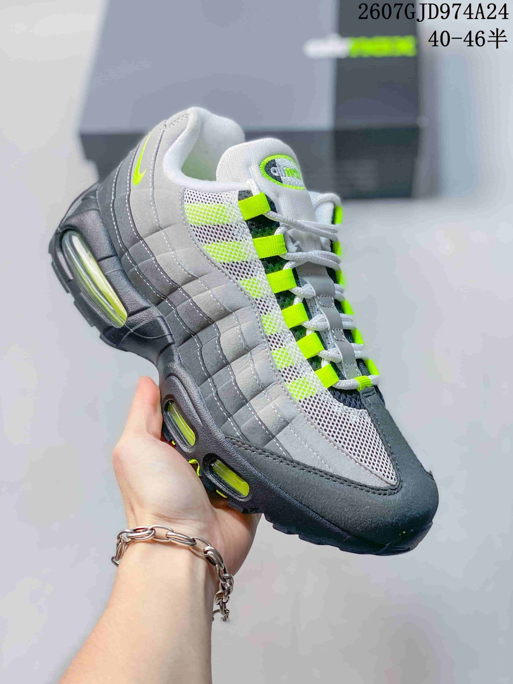Angled side view highlighting the layered grey and black upper, neon green accents and visible air cushioning windows.