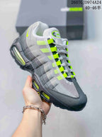 Angled side view highlighting the layered grey and black upper, neon green accents and visible air cushioning windows.