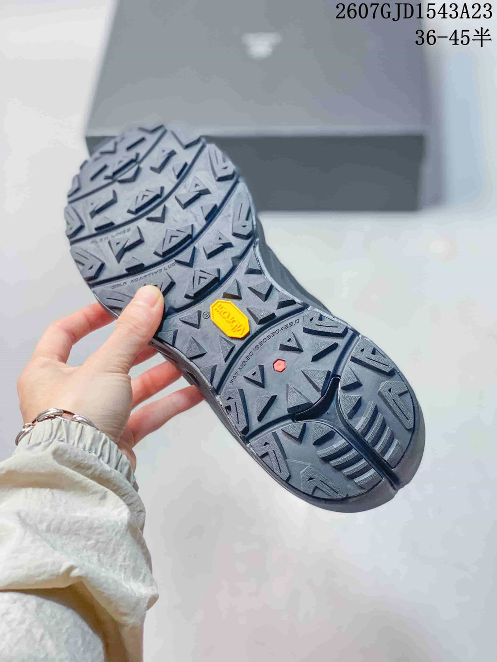 Underside view showing the sneakers' deep lugged outsole and visible branded insert.
