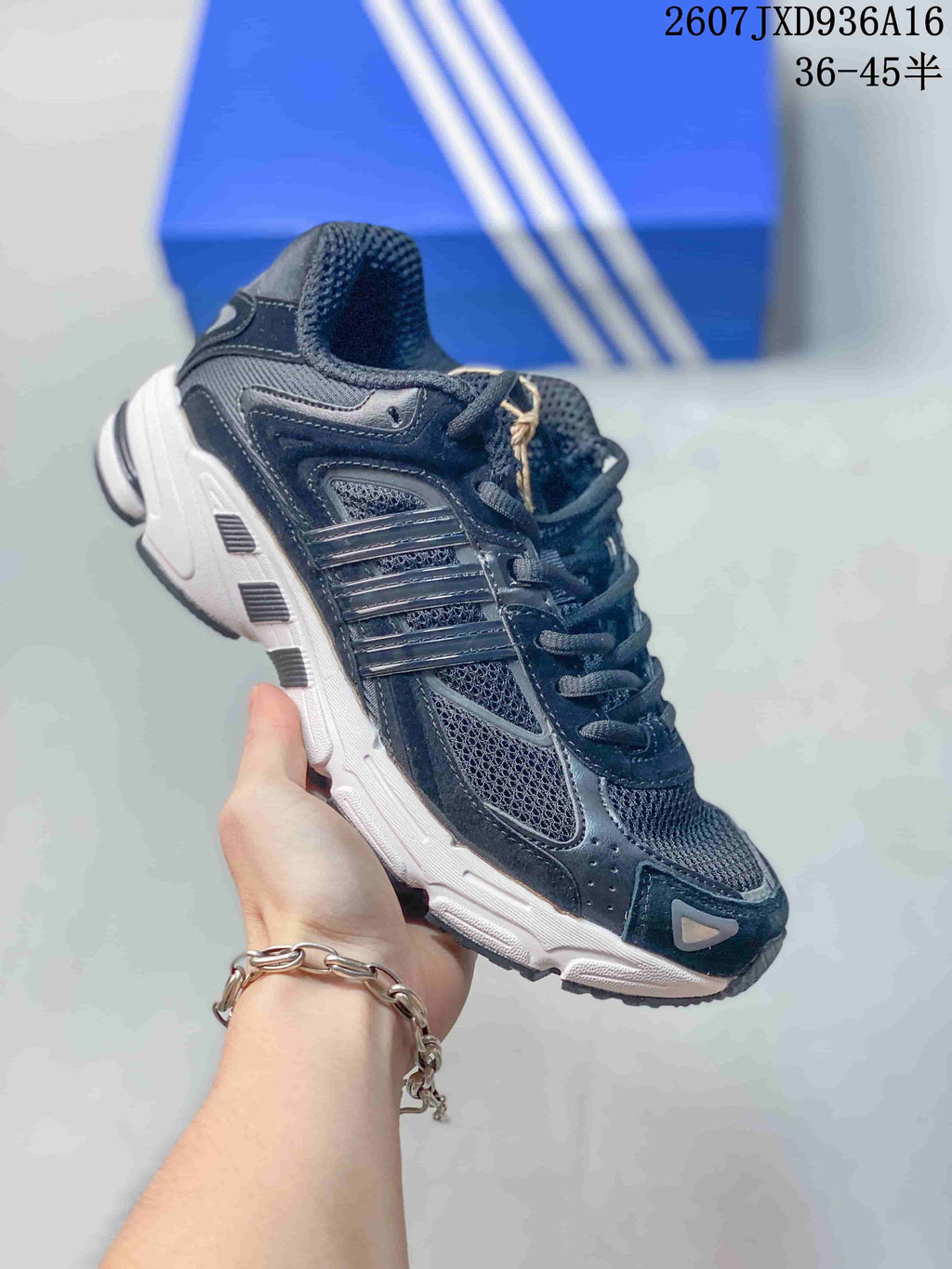 Three-quarter side view of the dark low-top sneaker with layered panels and contrasting outsole.
