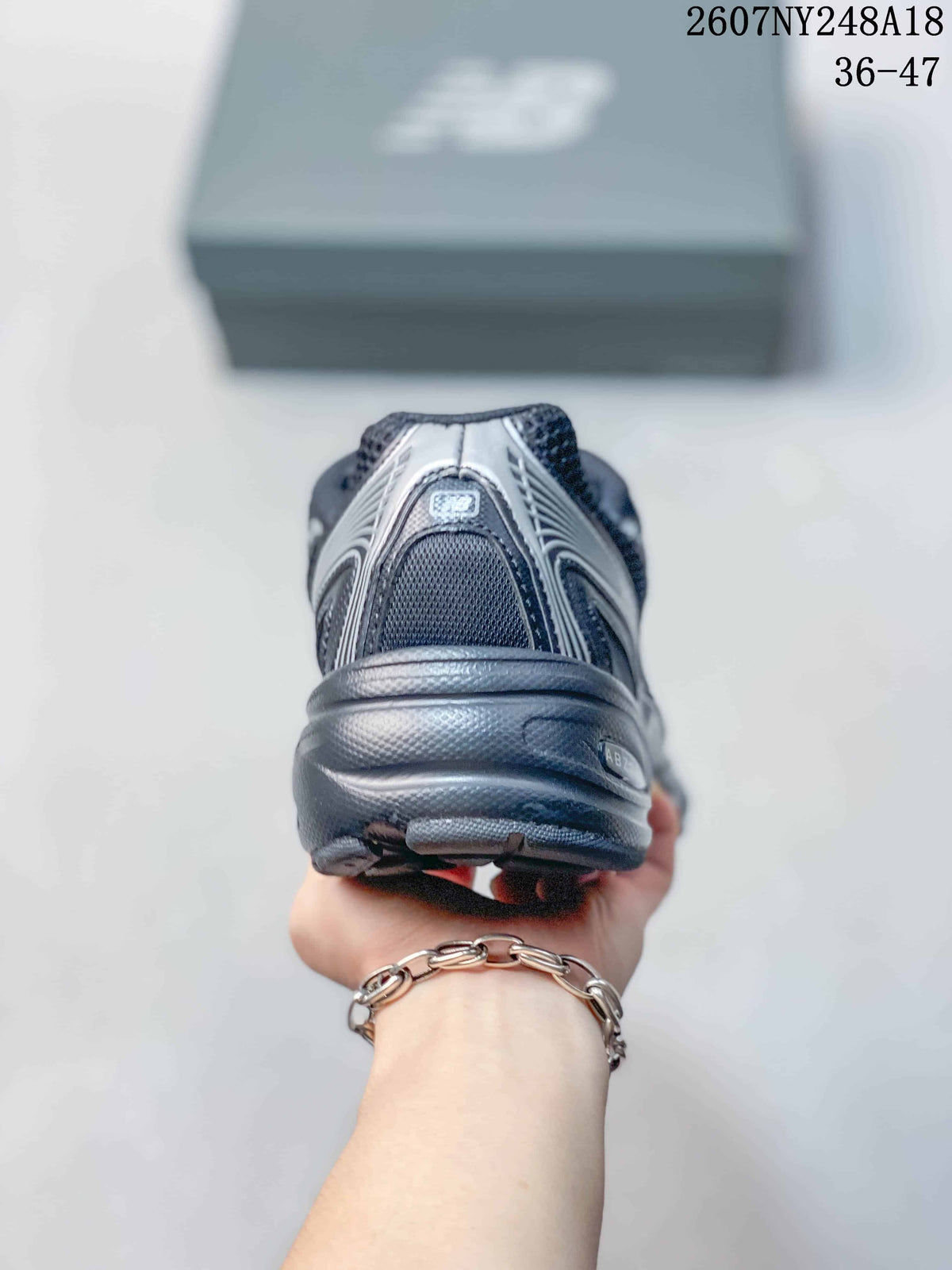 Rear view of a black and gray low-top sneaker highlighting the layered heel construction and outsole.