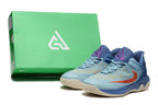Pair of blue Nike basketball shoes with orange-red accents beside a green shoe box