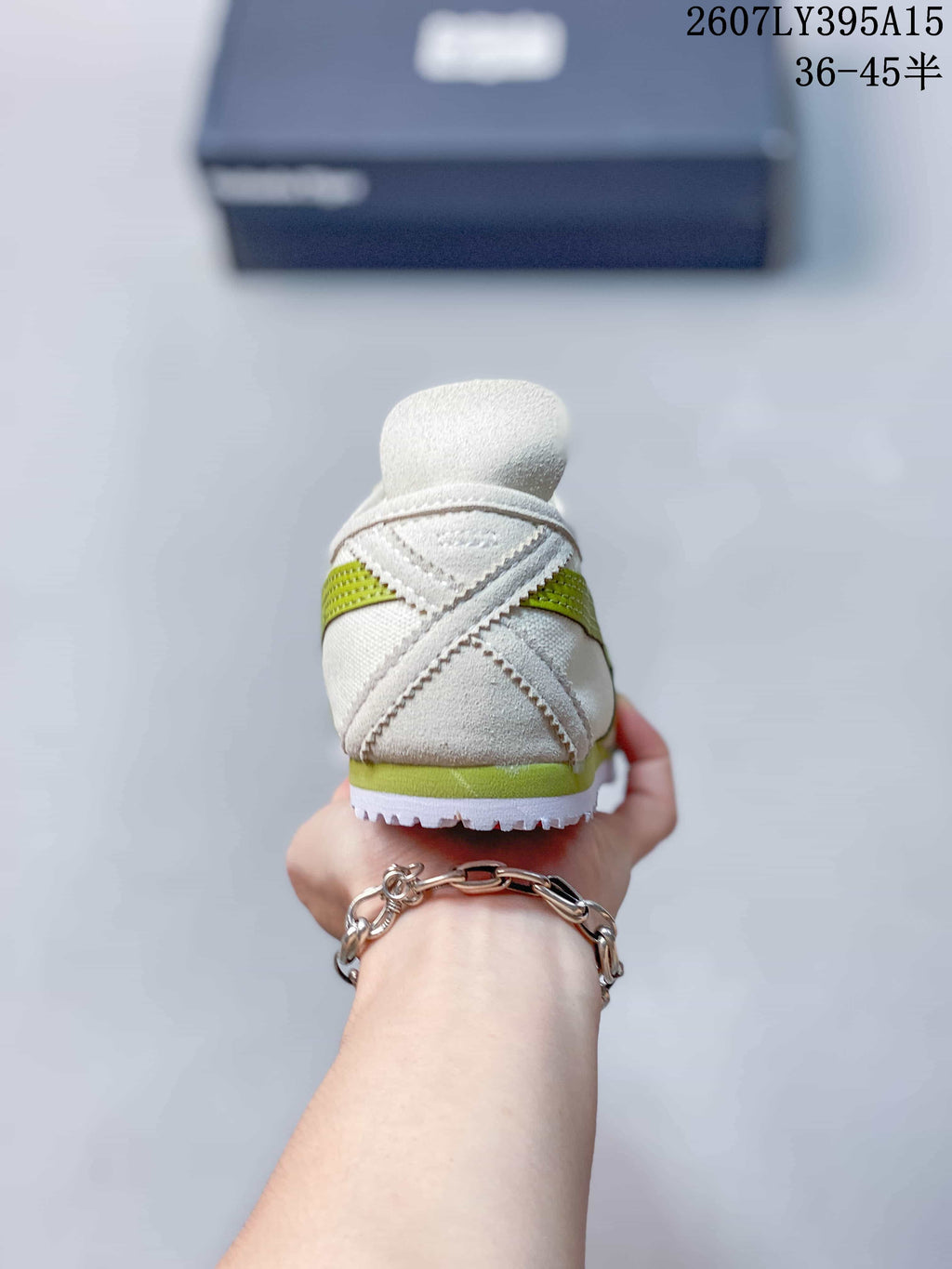 Rear view showing the layered heel construction, green heel accent, and textured outsole edge.