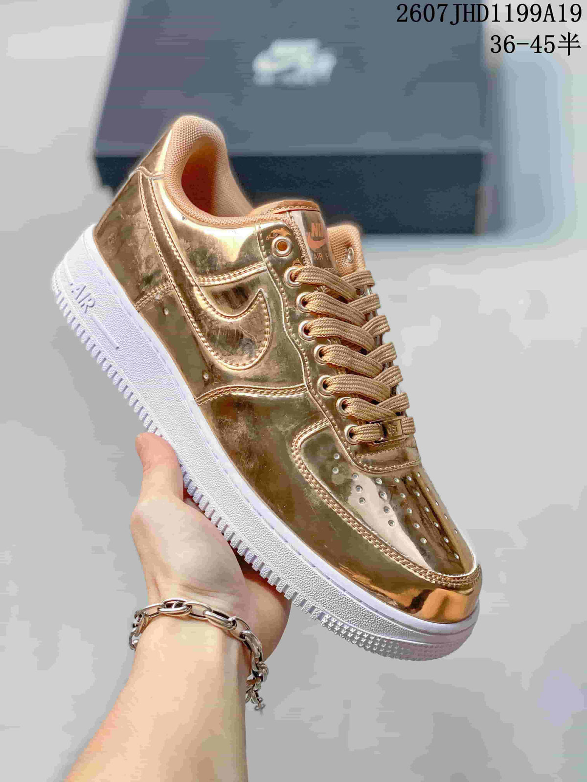 Angled side view showing the reflective metallic gold upper, Swoosh detail and white outsole.