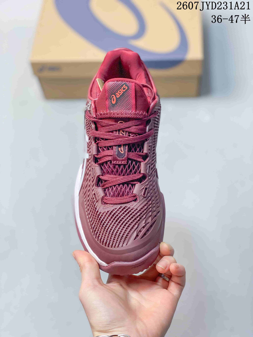 Top view of the burgundy tennis shoe showing the lace-up construction, mesh-textured upper, and branded tongue.