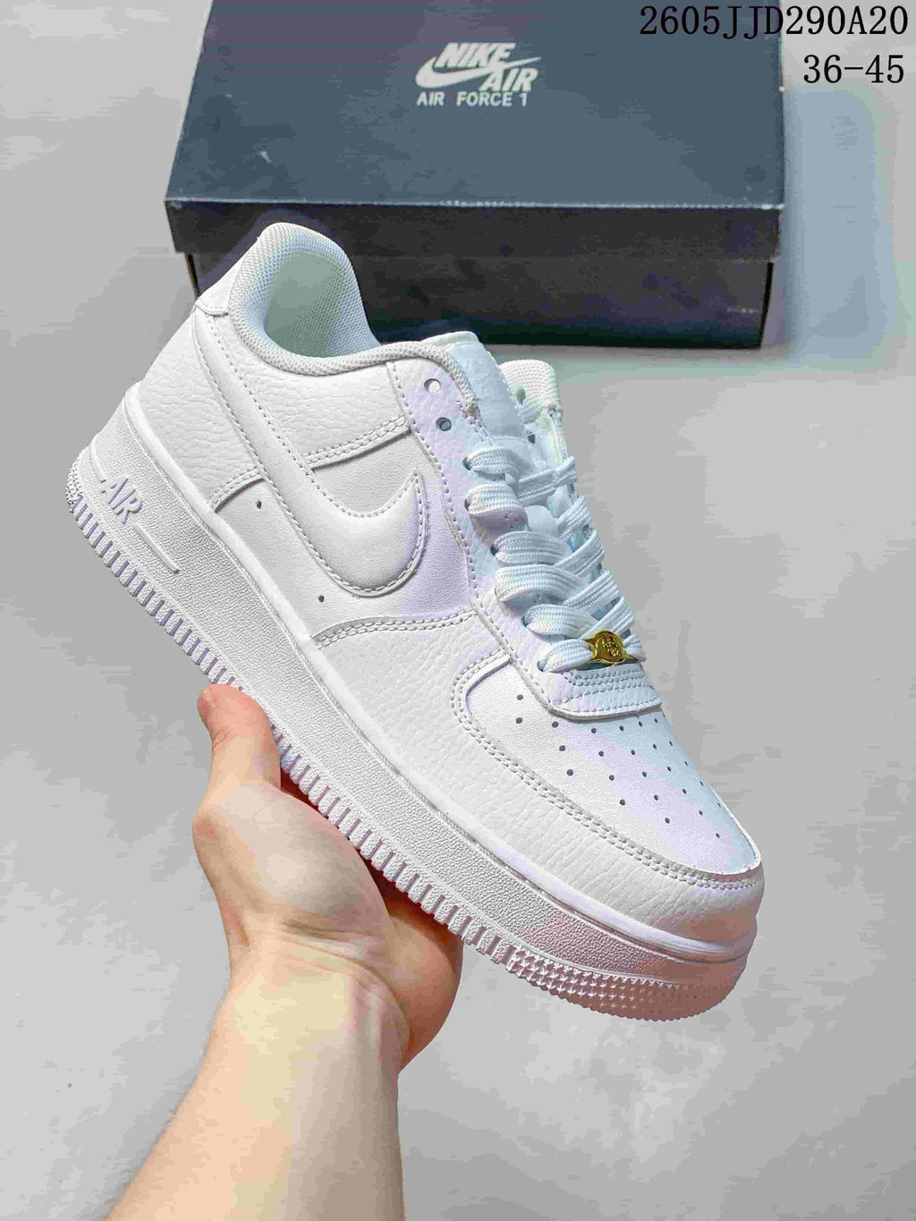 Close-up of an all-white Nike Air Force 1-style sneaker with a white Swoosh, white laces and a pale outsole.