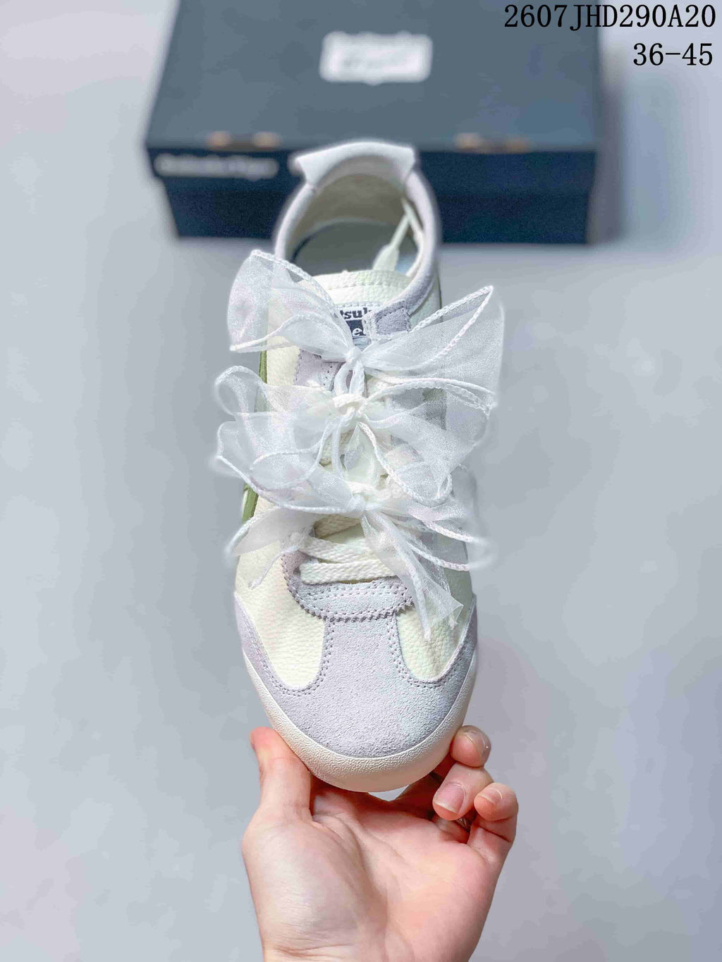 Top view showing the rounded toe, light gray overlays, white ribbon laces, and green side accents.