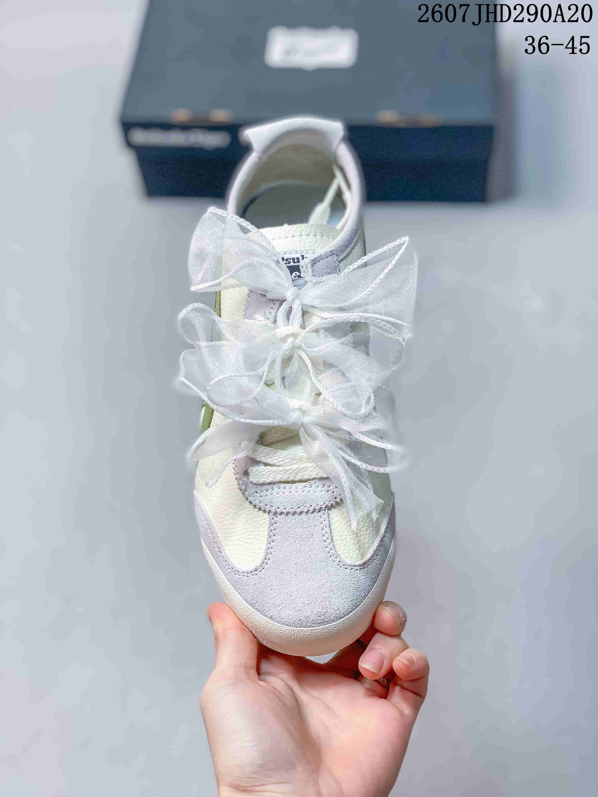 Top view showing the rounded toe, light gray overlays, white ribbon laces, and green side accents.