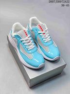 Pair of turquoise and white low-top lace-up sneakers shown on a shoebox, with red tongue branding.