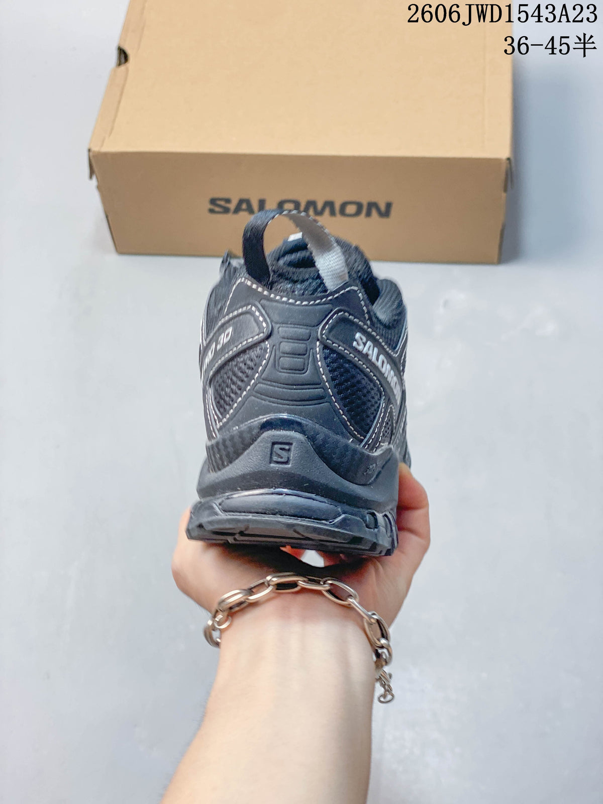 Rear view of a dark Salomon shoe showing heel panels and branding; image overlay lists sizes 36–45.5.