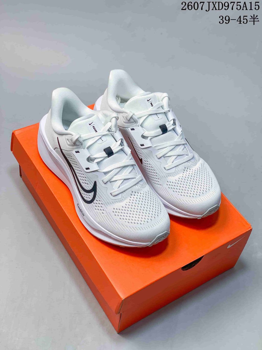 Pair of white Nike Quest 6 low-top running sneakers displayed on an orange shoe box.