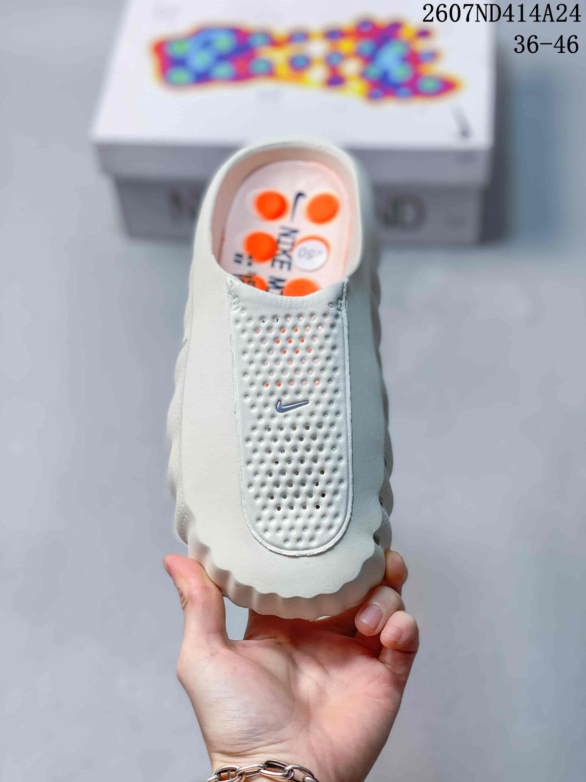 Top view of a white Nike Mind slip-on clog showing the perforated toe panel and small Swoosh detail.