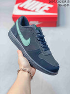 Angled side view of the black and mint-green low-top sneaker showing the perforated toe, stitched overlays, and textured outsole.