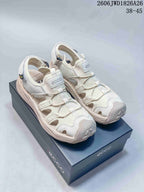 Pair of off-white open-toe sandals with perforated panels, heel straps, and bungee lacing.