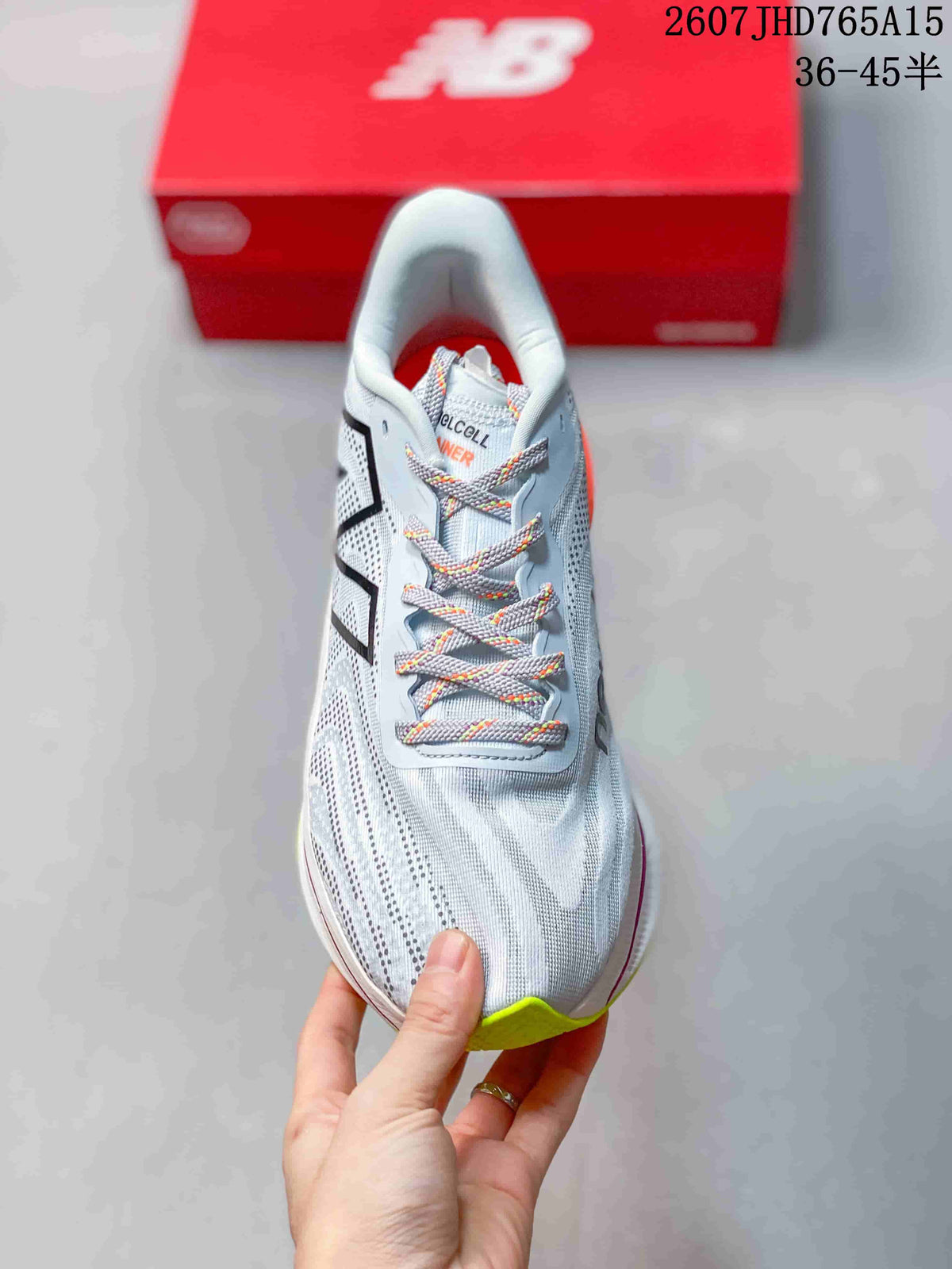 Front view of the light-colored running shoe showing the patterned laces, perforated upper, and lime toe outsole.