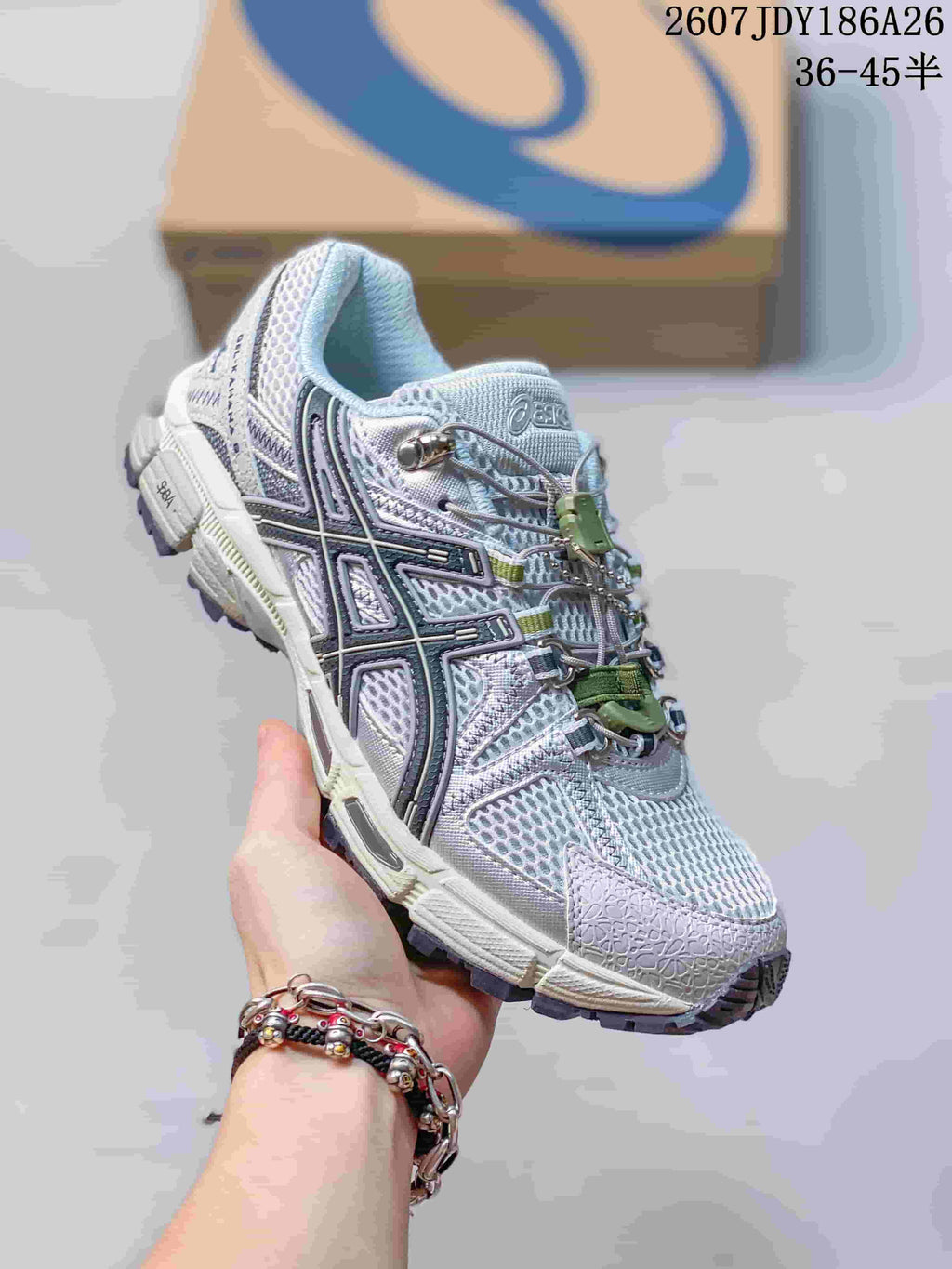 Angled side view of the ASICS Gel-Kahana 8 FL sneaker showing the layered upper, black side detailing, green lace hardware, and lugged outsole.