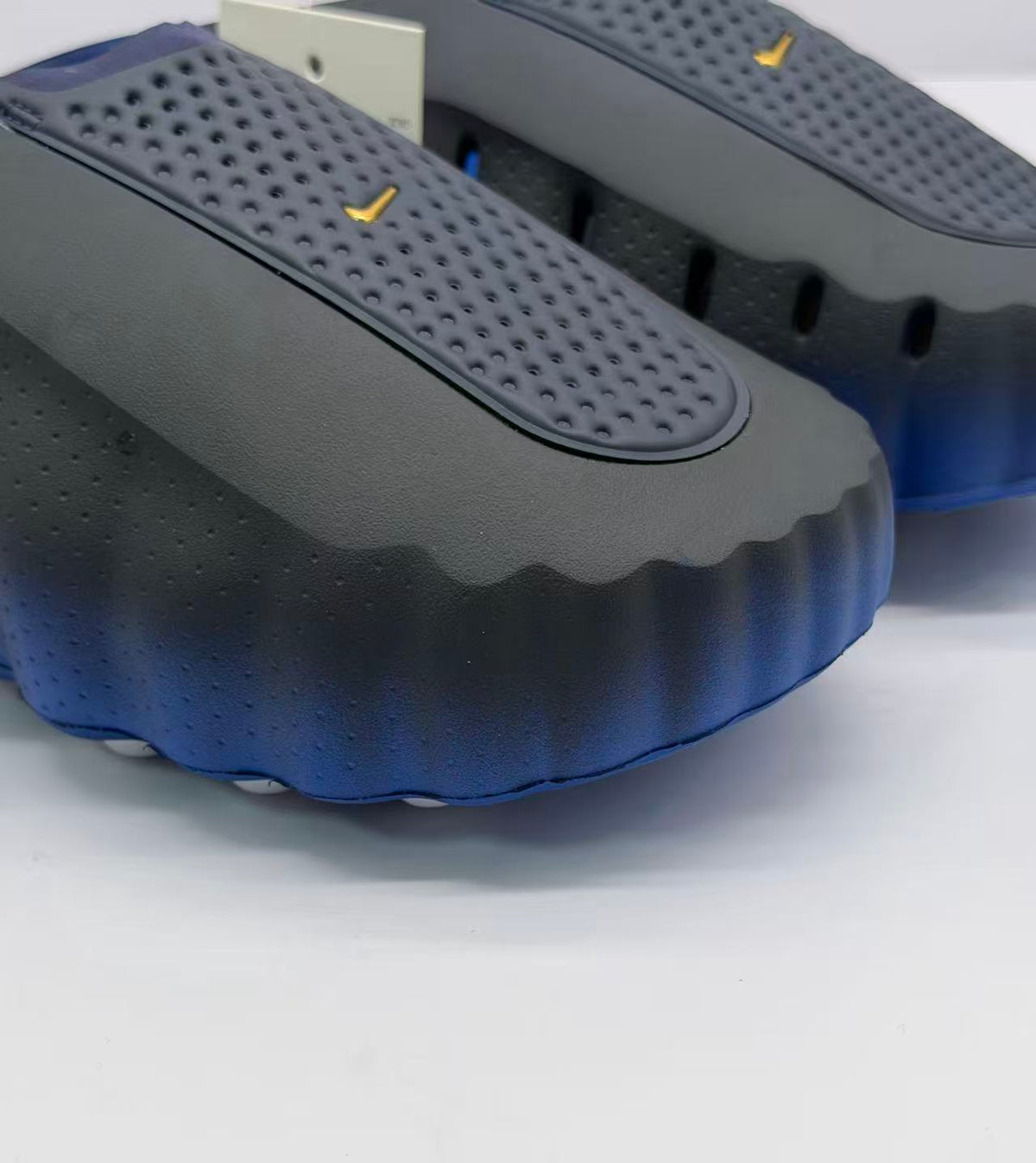 Close-up of the perforated upper, textured side panel, and scalloped outsole edge.