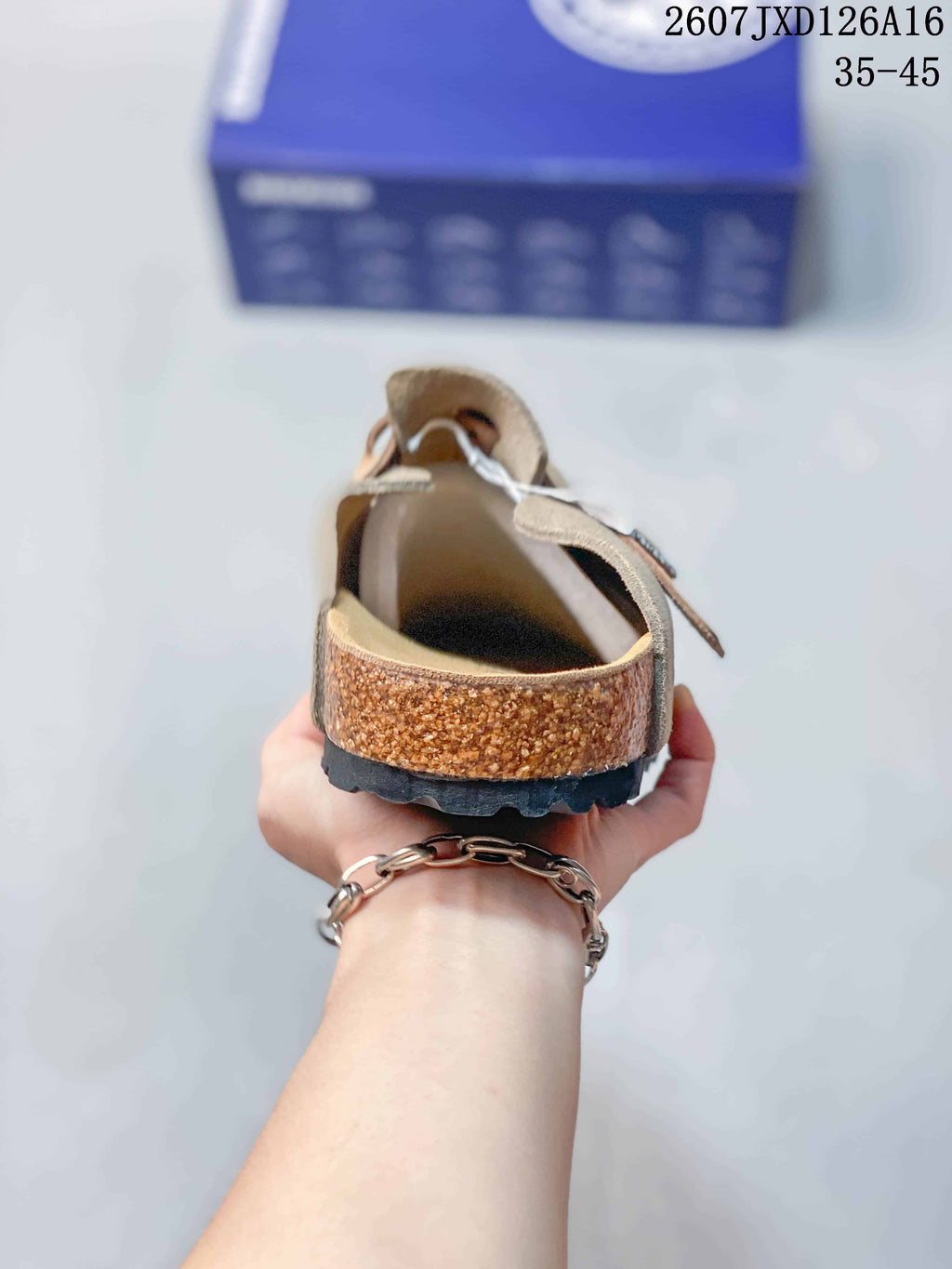 Rear view showing the cork-look sidewall, contoured footbed and black outsole of the taupe mule.