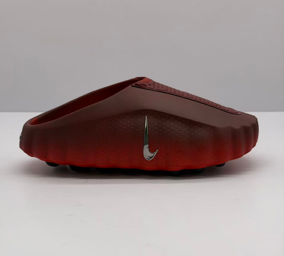 Side view of a dark red slip-on sneaker with a silver side swoosh and textured footbed.