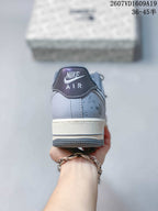 Rear view showing the Nike Air heel label, pale blue-gray upper, off-white midsole, and dark outsole.