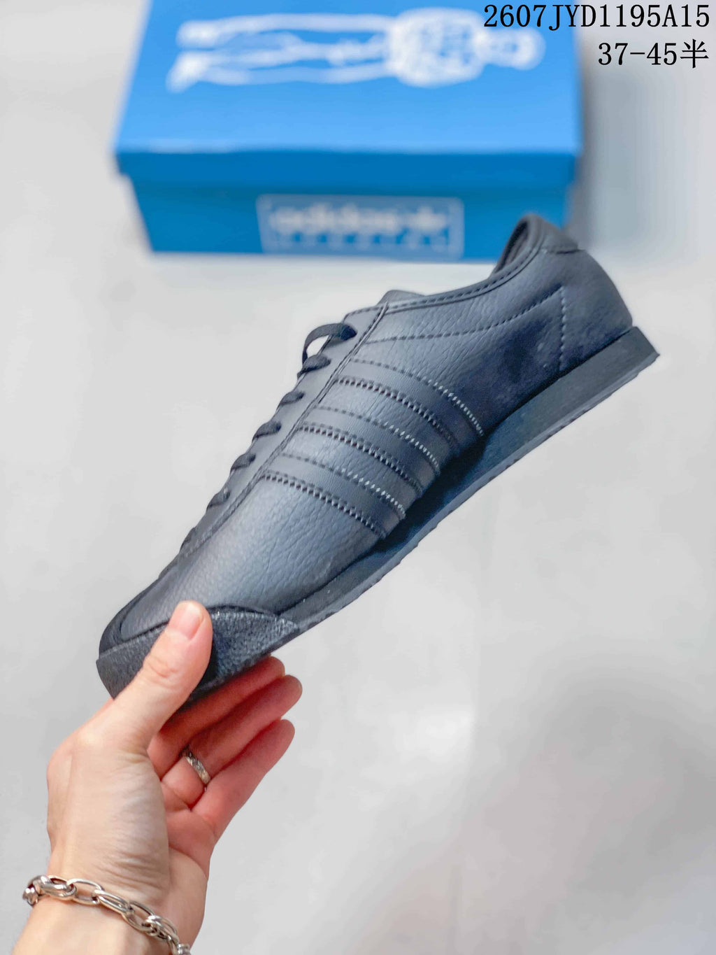 Side profile of the sneaker showing the low-top silhouette, tonal side stripes, stitched panels, and black sole.