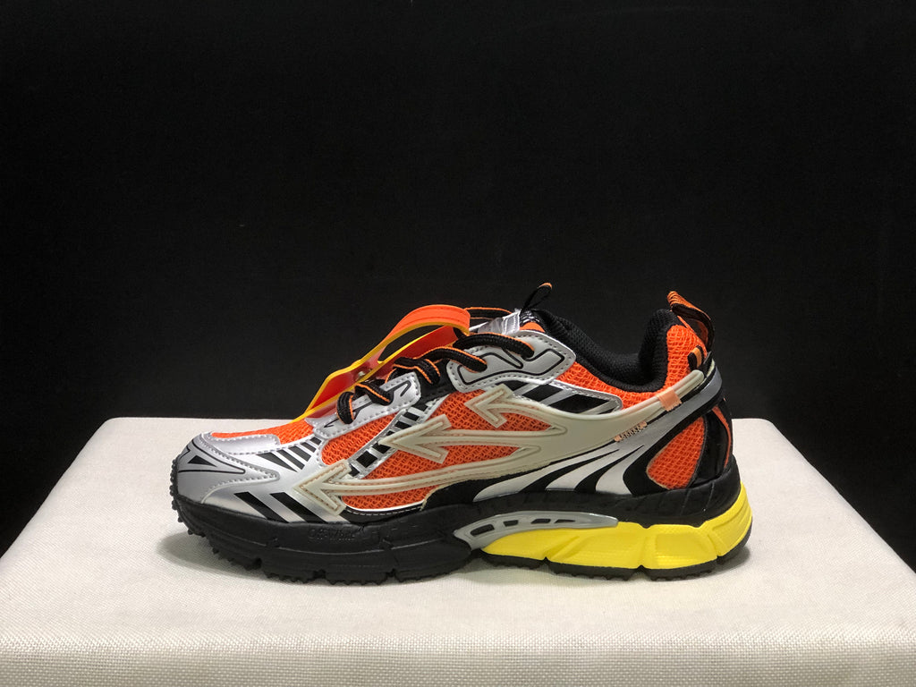 Inner side profile of an Off-White Be Right Back sneaker with orange mesh-like panels and layered black, silver, and yellow details.