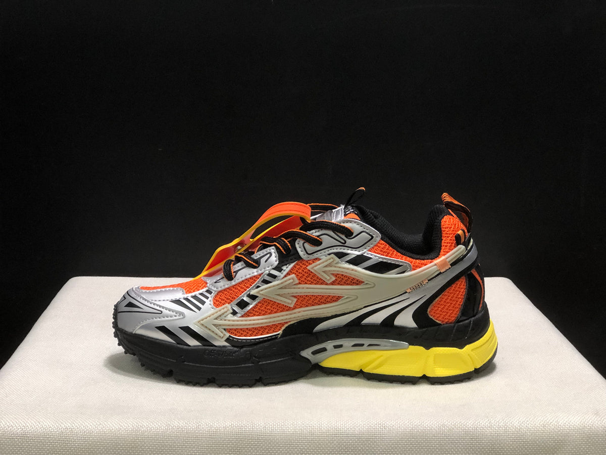 Inner side profile of an Off-White Be Right Back sneaker with orange mesh-like panels and layered black, silver, and yellow details.