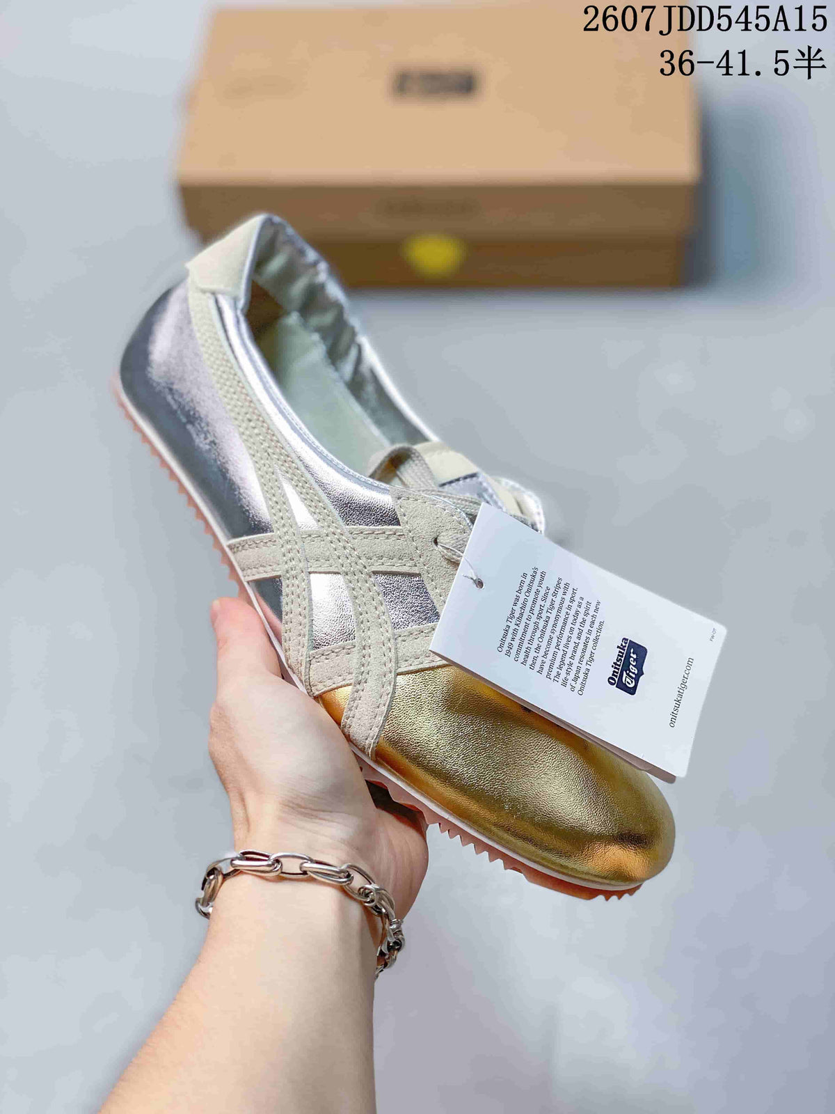 Silver low-top sneaker with light side stripes, a metallic gold insole, and a tan textured outsole.