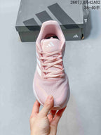 Front view of the pink lace-up running shoe with white side stripes.