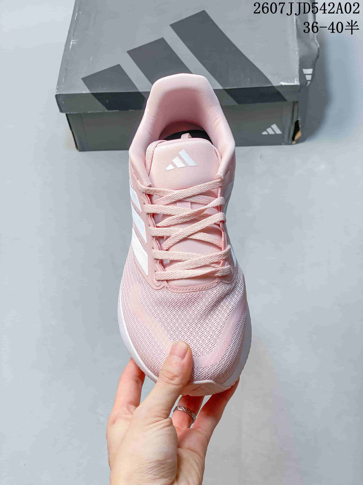 Front view of the pink lace-up running shoe with white side stripes.