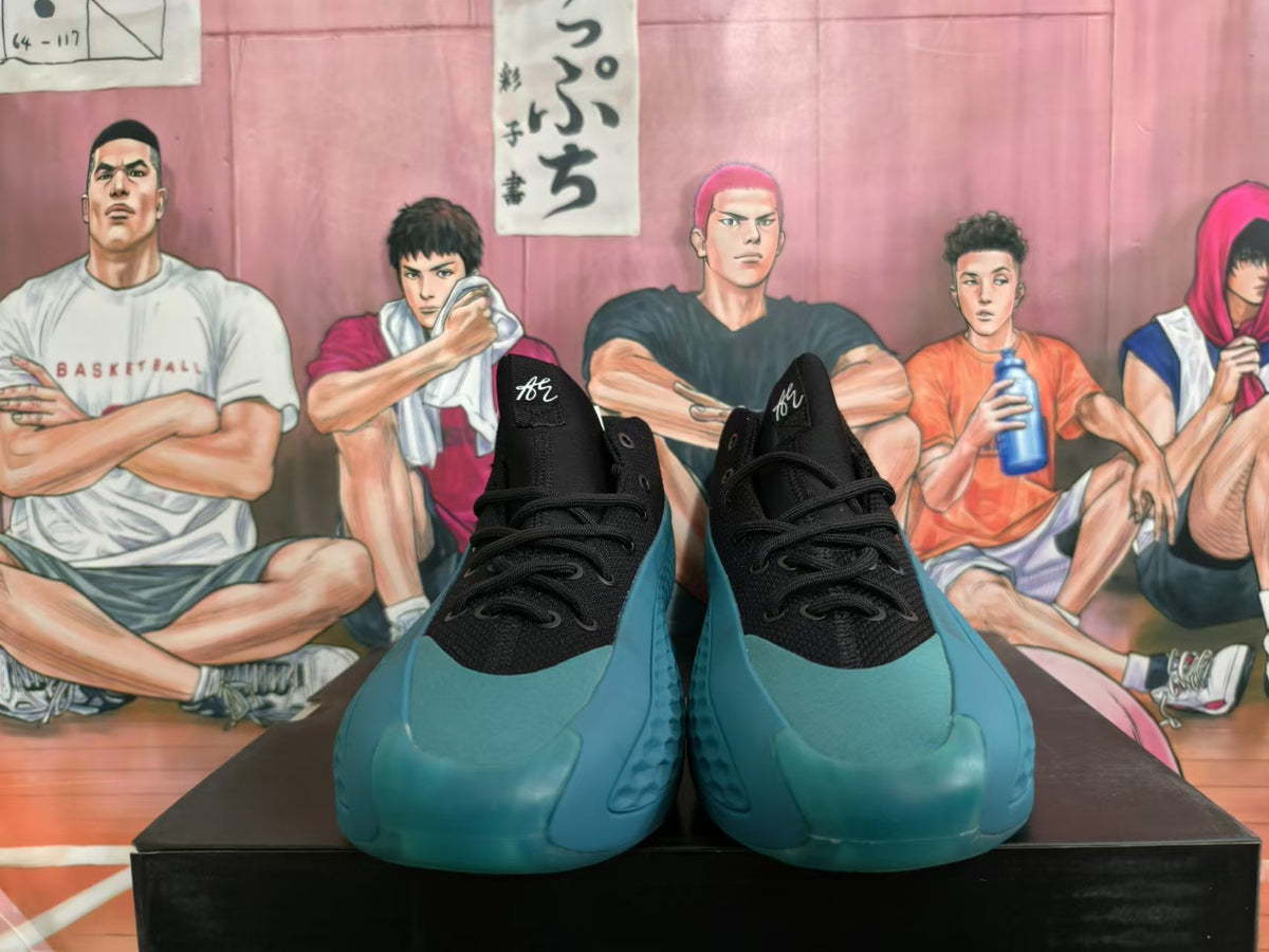 Front view of black lace-up basketball shoes with teal-colored toes and soles.