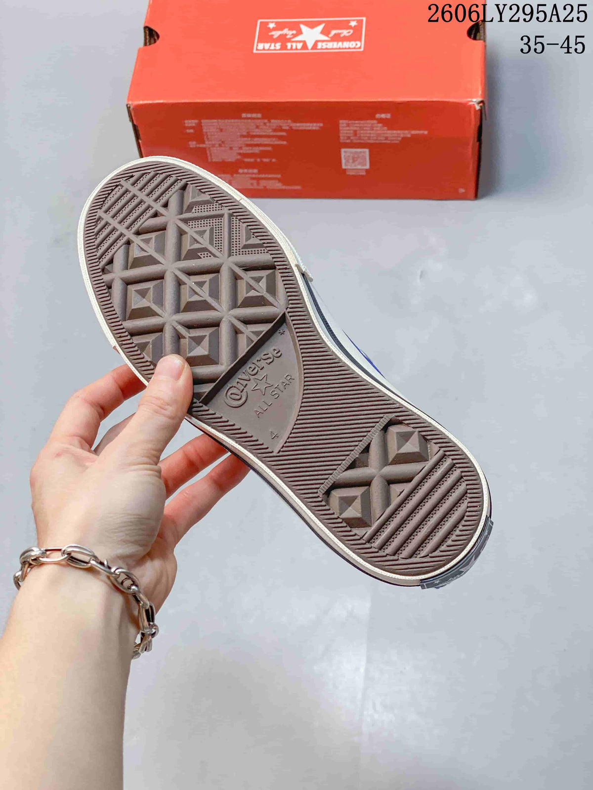 Close view of the textured geometric rubber outsole and red Converse shoe box.