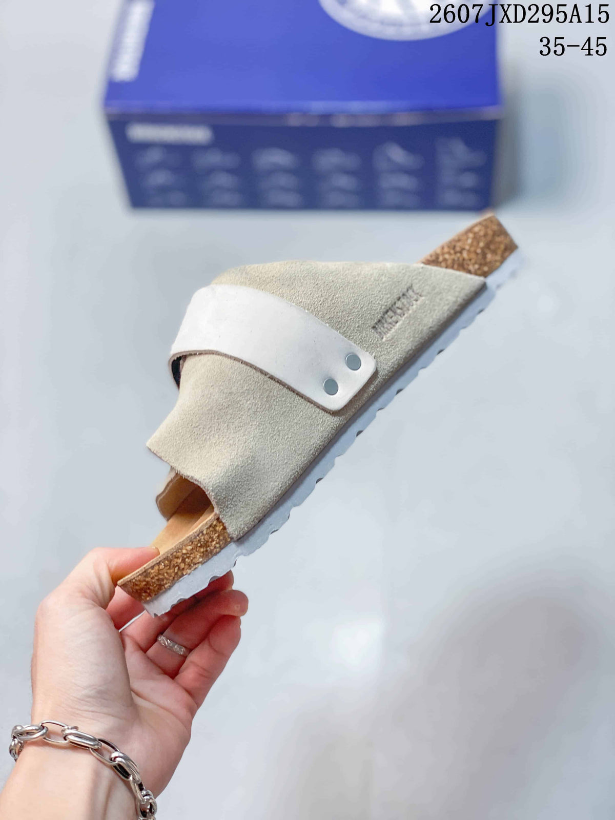 Side view of one light beige sandal showing the layered upper straps, adjustable buckle strap, contoured footbed, and cork-look midsole.