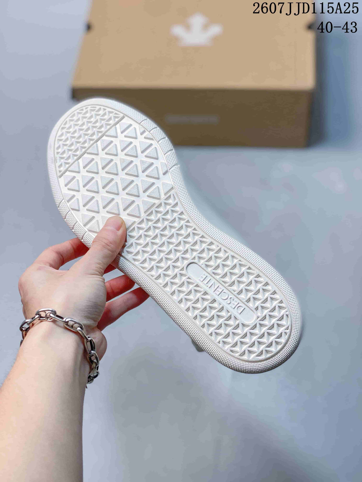 Close-up of the white patterned rubber outsole showing a geometric tread design and embossed branding.